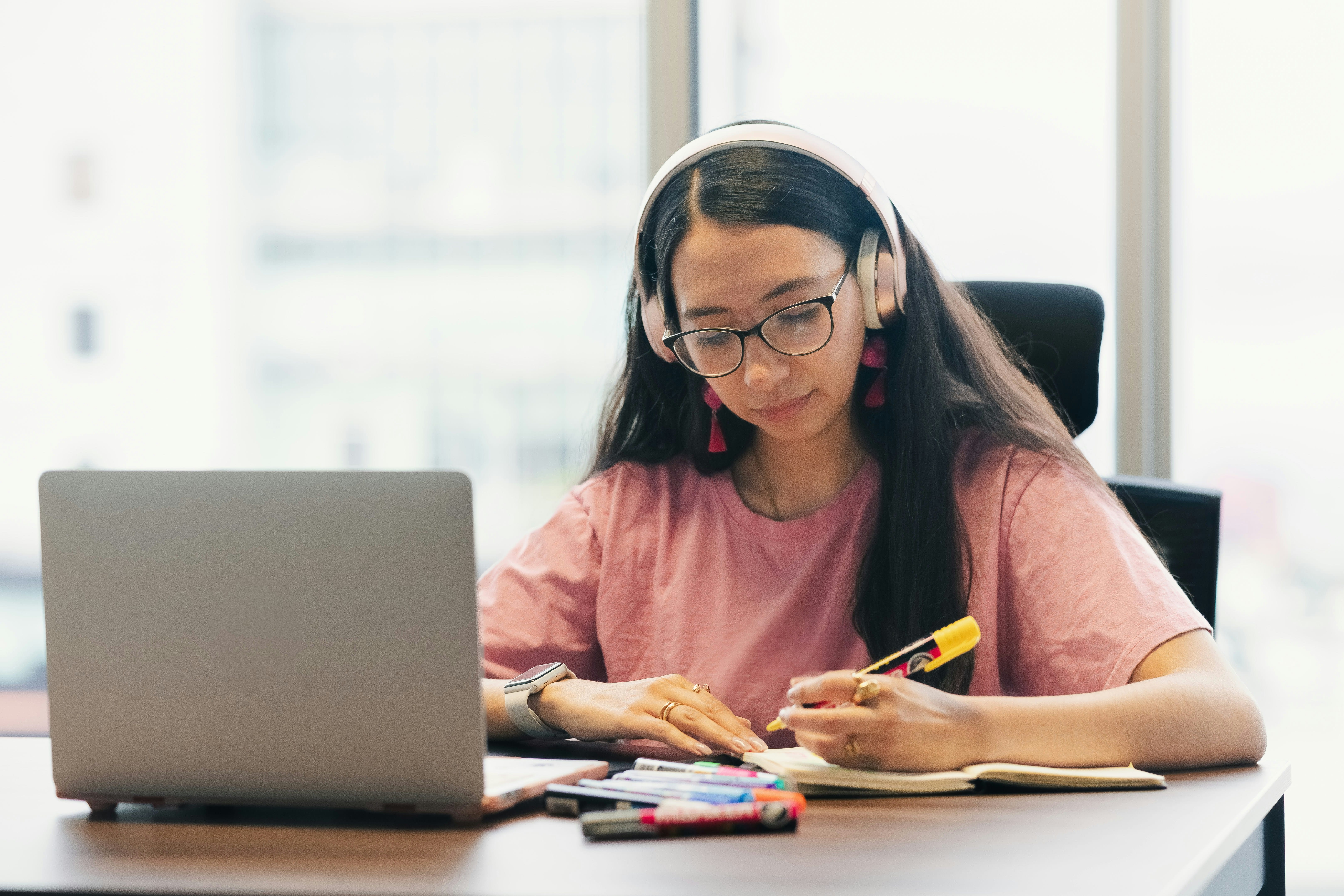 Teen student wearing headphones during an online French tutoring session on her laptop
